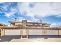 Beige two-story townhome featuring a red tile roof, attached garages, and white trim accents at 6909 Cobre Azul Ave # 202, Las Vegas, NV 89108