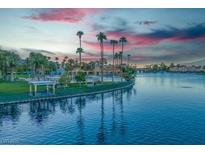 Scenic lakefront view with palm trees and walking path at sunset at 7624 Nocturne Ct, Las Vegas, NV 89128