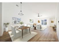 Bright, open-concept living and dining area with modern furnishings and hardwood floors at 10229 Birch Bluff Ln, Las Vegas, NV 89145