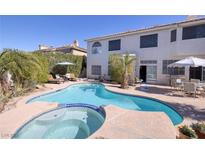 Backyard pool and spa with patio seating and lush landscaping, perfect for outdoor entertaining at 13 White Tail Ct, Henderson, NV 89074