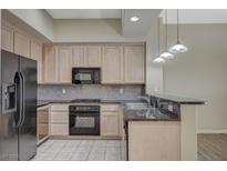 Bright kitchen features stainless steel appliances, wood cabinets, and granite countertops at 20 E Serene Ave # 304, Las Vegas, NV 89123