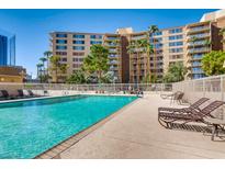 Beautiful outdoor pool area with lounge chairs and lush landscaping near the building at 205 E Harmon Ave # 704, Las Vegas, NV 89169