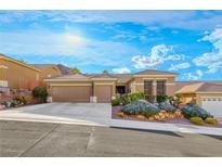 Charming single-story home featuring a well-manicured front yard with mature landscaping and an attached three-car garage at 2069 King Mesa Dr, Henderson, NV 89012