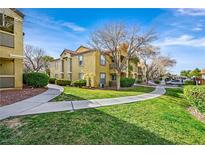 Inviting condo complex with mature landscaping, sidewalks, and well-maintained lawn at 2300 E Silverado Ranch Blvd # 1119, Las Vegas, NV 89183