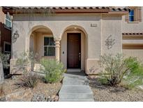 Charming front entrance featuring a covered porch with archways and a well-maintained landscaped yard at 10990 Mountain Willow St, Las Vegas, NV 89179