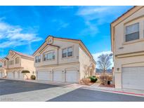 Charming townhomes featuring three garage spaces and neutral color scheme against a beautiful bright blue sky at 1631 Lefty Garcia Way, Henderson, NV 89002