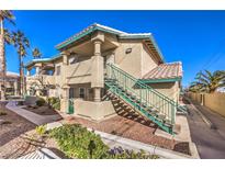 Charming two-story condo with landscaped yard, exterior stairs, and neutral stucco at 328 S Buffalo Dr # 101, Las Vegas, NV 89145