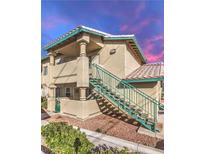 Beige two-story condo featuring a staircase leading to the upper unit and desert landscaping at 328 S Buffalo Dr # 101, Las Vegas, NV 89145
