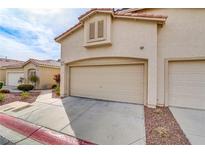 Exterior view of a two-car garage with beige doors and a red tile roof on a sunny day at 3425 Conan St # 103, Las Vegas, NV 89129