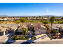 Expansive aerial view of a single story home with a tile roof situated on a golf course with mountain views at 4796 Riva De Romanza St, Las Vegas, NV 89135