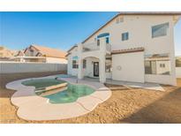 Backyard showcasing a kidney-shaped pool and a two-story white house with a small balcony at 6436 Heatherton Ave, Las Vegas, NV 89110
