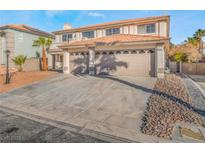A two story house with a three car garage and desert landscaping at 8212 Fawn Brook Ct, Las Vegas, NV 89149