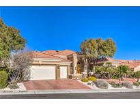 Charming single-story home featuring a tile roof, three-car garage, and desert landscaping at 10700 Back Plains Dr, Las Vegas, NV 89134