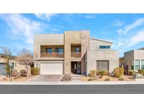 Contemporary two-story home featuring stone accents, balcony, and manicured landscaping at 3004 Barrett Springs Ave, Henderson, NV 89044