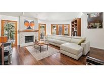 Bright living room with a sleek fireplace, hardwood floors, and a large sectional sofa at 7315 Mission Hills Dr, Las Vegas, NV 89113