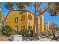 Charming condo featuring an stucco exterior, private balcony, and mature shade trees creating a welcoming curb appeal at 7950 W Flamingo Rd # 1081, Las Vegas, NV 89147