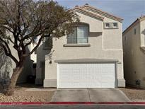 Two-story home featuring a two-car garage and neutral stucco, complemented by a mature tree in the front yard at 2504 Trustworthy Ave, North Las Vegas, NV 89031