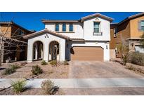 Charming two-story home with a two-car garage and inviting front porch with beautiful stone driveway at 294 Dedication Ave, Henderson, NV 89011