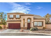 Two-story home featuring a red garage door, desert landscaping, and an arched entryway at 3401 Bedfordshire Pl, Las Vegas, NV 89129