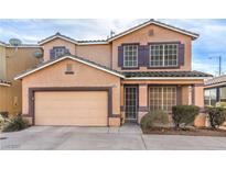 Charming two-story home featuring purple shutters, beige stucco, a brown-colored garage door, and well-maintained front yard landscaping at 5087 Midnight Oil Dr, Las Vegas, NV 89122