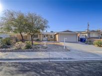Charming single-story home featuring a spacious driveway and mature landscaping under a clear blue sky at 5305 Doe Ave, Las Vegas, NV 89146