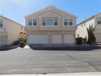 Inviting exterior view of a two-story condo with a three-car garage and neutral paint at 8635 Tomnitz Ave # 103, Las Vegas, NV 89178