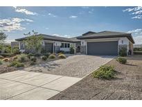 Beautiful single-story home featuring a three-car garage, desert landscaping, and a charming stone facade at 9475 W Rosada Way, Las Vegas, NV 89149