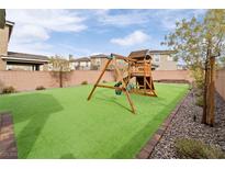 A spacious backyard features a playground, artificial grass, and perimeter stone at 2848 Mozia Ct, Henderson, NV 89044