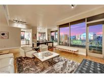 Elegant living room featuring a pool table and stunning floor-to-ceiling views of the city skyline at sunset at 360 E Desert Inn Rd # 404, Las Vegas, NV 89109