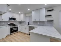 Modern kitchen featuring white cabinets, stainless steel appliances, and stylish countertops at 5612 Open Ct, Las Vegas, NV 89118