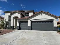 Charming two-story home featuring a spacious three-car garage and desert landscaping in front yard at 9272 W Viking Rd, Las Vegas, NV 89147