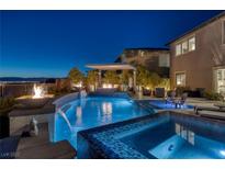Stunning pool with spa, fire features, and covered patio is perfect for outdoor entertaining with scenic views at 2171 King Crest Ct, Henderson, NV 89052