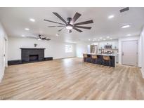 Bright, open living room with a fireplace and a modern kitchen island with seating at 5203 Reeder Cir, Las Vegas, NV 89119