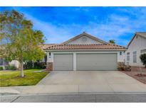 Charming home featuring a spacious two-car garage with stone accents and a well-maintained front yard at 1107 Cloudy Day Dr, Henderson, NV 89074