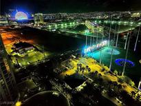 Brightly lit nighttime aerial view of a Topgolf facility with the Las Vegas strip in the background at 135 E Harmon Ave # 2120, Las Vegas, NV 89109