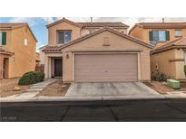 Beige two-story home featuring a two-car garage, desert landscaping and a tile roof at 6949 Copper Bracelet Ave, Las Vegas, NV 89122
