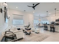 Bright, open-concept living room with sleek white sectional and modern decor at 795 Sunny Sagebrush St, Henderson, NV 89011