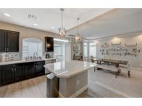Modern kitchen featuring black cabinets, an island with white countertop, and stainless steel appliances at 9835 Fox Estate St, Las Vegas, NV 89141