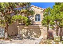 Two-story tan home featuring a two-car garage and well-maintained landscaping at , Las Vegas, NV 89118