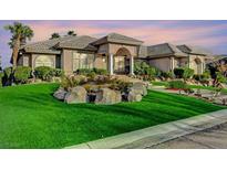 Beautiful exterior view of a house with a well-manicured lawn and rock features, showcasing its curb appeal at 1700 Brock Ct, Las Vegas, NV 89117