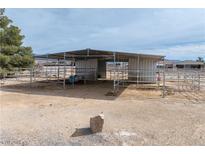 Outdoor barn structure with metal roof and horse fencing in a desert landscape, perfect for equestrian activities at 3581 Ranger Way, Pahrump, NV 89048