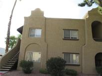 Two-story building featuring beige stucco, multiple windows, arched details, and exterior staircase at 5161 Pioneer Ave # 203, Las Vegas, NV 89146