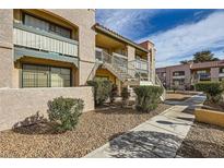 Exterior of building shows landscaped ground, stairs lead up to units above the ground floor at 5162 S Jones Blvd # 108, Las Vegas, NV 89118
