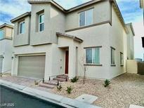 Inviting two-story home with neutral stucco, a two-car garage, and small landscaped front yard at 6840 Sunflower Fields St, North Las Vegas, NV 89086