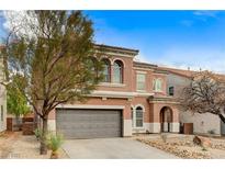 Two-story home featuring a covered porch, desert landscaping, and an attached two-car garage at 7158 Clear Range Ave, Las Vegas, NV 89178