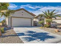 Charming single-story home with desert landscaping, mature palm trees, and a two-car garage at 7461 Crested Quail St, North Las Vegas, NV 89084