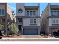 Modern three-story home with a gray exterior, two-car garage, and manicured front yard at 8144 Monsoon Bay St, Las Vegas, NV 89113