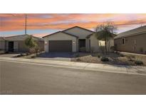 Charming single-story home boasts desert landscaping and a two-car garage under a lovely sunset at 2255 Woodbluff Ave, North Las Vegas, NV 89086