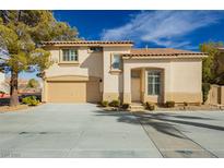 Charming two-story home featuring a tan exterior, tile roof, attached garage, and landscaped front yard in a sunny neighborhood at 2345 Cliffwood Dr, Henderson, NV 89074