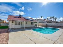 Sparkling backyard pool with a covered patio, solar panels, and mature landscaping at 312 Manor St, Las Vegas, NV 89145